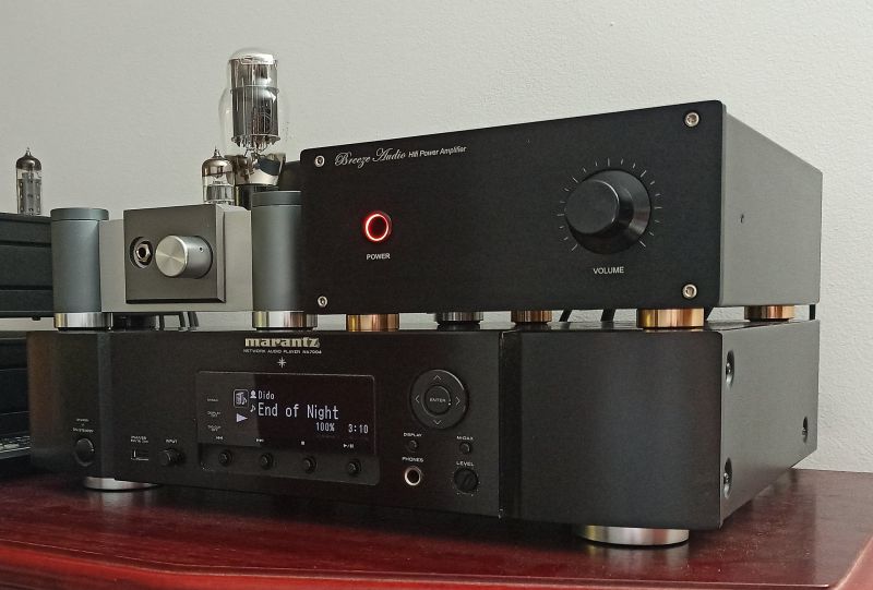 Wzmacniacz Breeze Audio i odtwarzacz Marantz NA7004 Wzmacniacz audio Breeze Audio HiFi i sieciowy odtwarzacz Marantz NA7004 ustawione na drewnianym blacie.