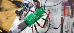 Electronic board with soldered wires connected to a USB-TTL adapter.