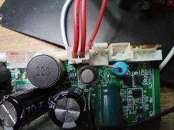 Zbliżenie na płytkę drukowaną z kondensatorami 470 µF i 220 µF oraz przewodami czerwonymi