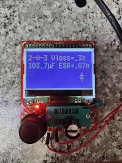 Tester komponentów elektronicznych wyświetlający pomiar kondensatora: 103,7µF, ESR 0,07Ω, Vloss 3%.