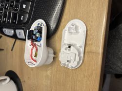 Geöffnetes Smart-Steckdose mit sichtbarer Elektronik und abgenommenem Gehäuse