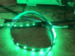 Green Glowing LED Strip LED strip glowing green with connected wires.