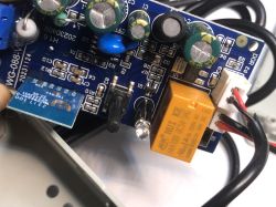 Inside of the ATLO-GDC2-TUYA Garage Door Controller Close-up of the ATLO-GDC2-TUYA garage door controller PCB with a HUI KE relay, capacitors, and connected wires.
