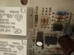 Zbliżenie płytki PCB z przekaźnikami, rezystorami, kondensatorem i układem scalonym DIP