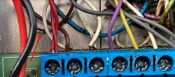 Zdjęcie panelu z przewodami elektrycznymi, gdzie brązowy przewód jest wypięty i dotyka obudowy.