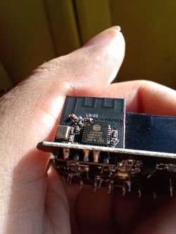 Close-up of an electronic module with LN-G2 chip held in a hand.