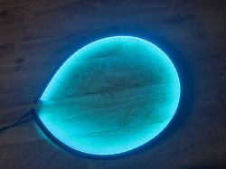 Illuminated LED strip emitting light blue light on a floor.