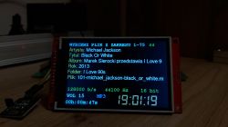 LCD screen MP3 player displaying info about Black Or White track
