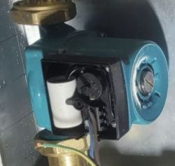 Zbliżenie na pompę wodną z niebieską obudową i metalowym złączem.