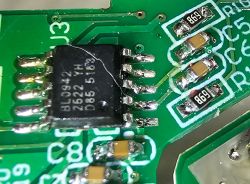 Close-up of a green PCB with an IC and SMD parts, including resistors marked 889.