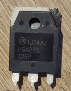 Zbliżenie na element elektroniczny, tranzystor oznaczony jako ON 1J24AJ FGA25S 125P na drewnianej powierzchni.