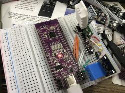Breadboard with a microcontroller and several sensors connected by wires.