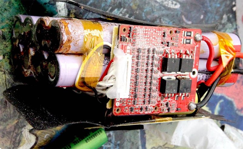 Zestaw ogniw 18650 z uszkodzoną elektroniką i śladami rdzy oraz wycieku