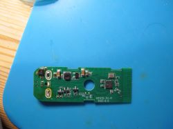 Printed circuit board with various electronic components on a blue background.