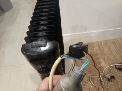 Electric heater with visible wires and a connector.