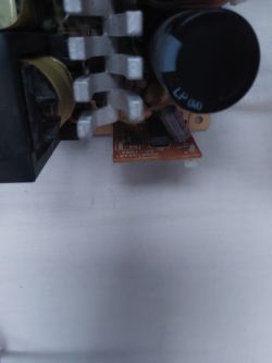 Elementy elektroniczne na płytce PCB, w tym radiator i kondensator, bez widocznych miejsc na przewody.