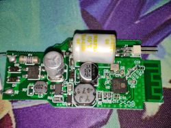 The image shows a printed circuit board (PCB) with various electronic components including capacitors, resistors, coils, and integrated circuits.