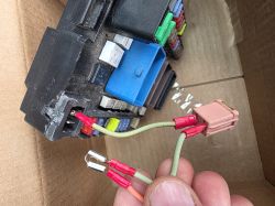 Ręka trzyma wiązkę kabli z konektorami przy module BSM Peugeot 508, przygotowaną do obejścia elektrycznego.