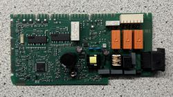 Płytka drukowana z różnymi komponentami elektronicznymi na szarym tle.