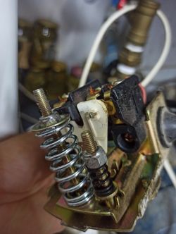 Zbliżenie na części mechanizmu pompy ciśnieniowej z widocznymi sprężynami i elementami montażowymi.