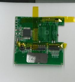 Green PCB with integrated circuits and an FPC ribbon on a white background