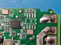 Close-up of green PCB with microchip, SMD components, and solder joints