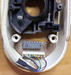 Interior of an Amiga computer mouse with cables and a wiring diagram.