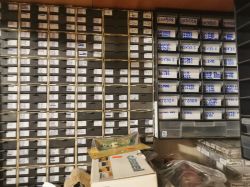 Wiele półek z plastikowymi szufladkami z opisami zawartości, służącymi do przechowywania części elektronicznych.