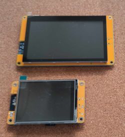 Two display modules of different sizes, 2.8 and 4.3, placed on a cork surface.