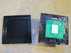 Disassembled Touch Switch with PCB Disassembled touch switch with visible PCB and casing.
