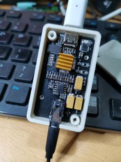 DIY USB Sound Card in Casing Interior of a DIY USB sound card prototype in a white casing on a keyboard.