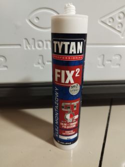 Tuba kleju montażowego Tytan Fix2 na tle lodówki.