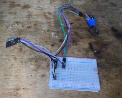Electronic Module on Breadboard Breadboard connected with an electronic module and wires on a wooden surface.