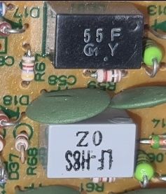 Zbliżenie na dwa filtry pośredniej częstotliwości wlutowane w płytkę PCB radia, oznaczone „55F C.Y” i „L-H85 02”.