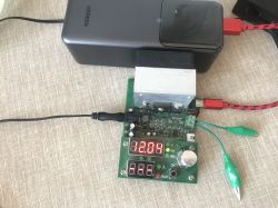 UGREEN power bank connected to a test board with LED display showing 12.04