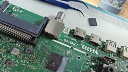 Płyta główna z portami HDMI i USB, pęsetą oraz wylutowanym układem leżącym obok