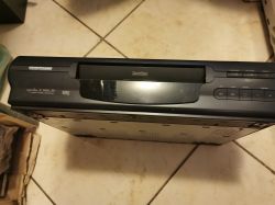 Odtwarzacz VHS marki Nordmende stojący na podłodze z widocznym panelem przednim i przyciskami.