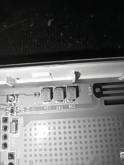 Trzy kondensatory elektrolityczne SMD oznaczone jako 227 6K 104 na płytce drukowanej, pokazane w zbliżeniu.