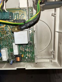 Close-up of a circuit board in a device with visible wires and electronic components.