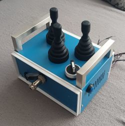 Niebieska konsola z trzema joystickami i jednym pokrętłem na górze.