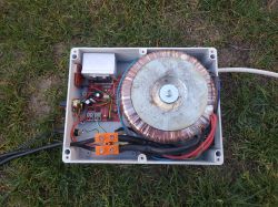 Zgrzewarka punktowa z transformatorem toroidalnym i elektroniką zamontowana w plastikowej obudowie na trawie.