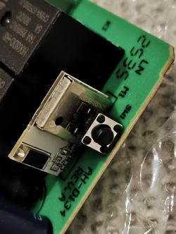 Close-up of a button and USB port on a green printed circuit board