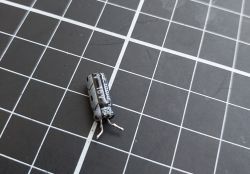Used Electrolytic Capacitor Electrolytic capacitor 10V 100μF lying on a grid mat.