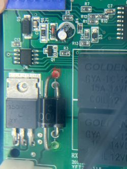 Elementy elektroniczne na płytce drukowanej z zaznaczonym czerwonym kółkiem.