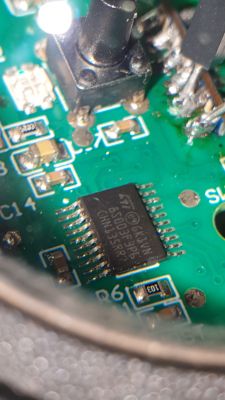 Circuit Board with Integrated Circuit and Button Close-up of a circuit board with integrated circuits and a button.