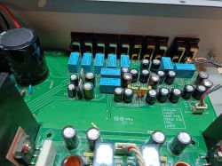 Widok wnętrza wzmacniacza z kondensatorami i przekaźnikami na płytce PCB