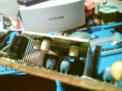 Zbliżenie na płytę PCB z wymienionymi kondensatorami SMD i elementami elektronicznymi.