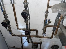 Rury instalacji grzewczej z pompami Grundfos w kotłowni.