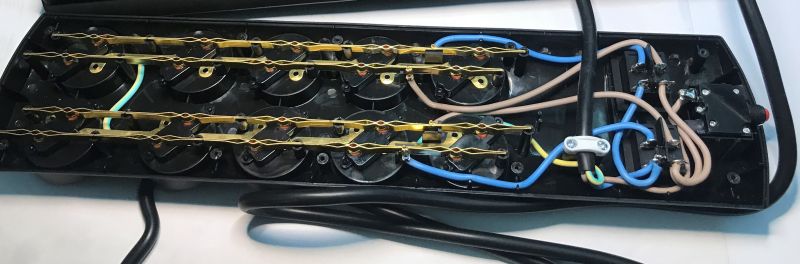 Wnętrze listwy zasilającej z widoczną instalacją elektryczną i przewodami