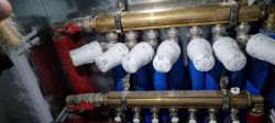 Instalacja ogrzewania podłogowego z termostatami na rurach.